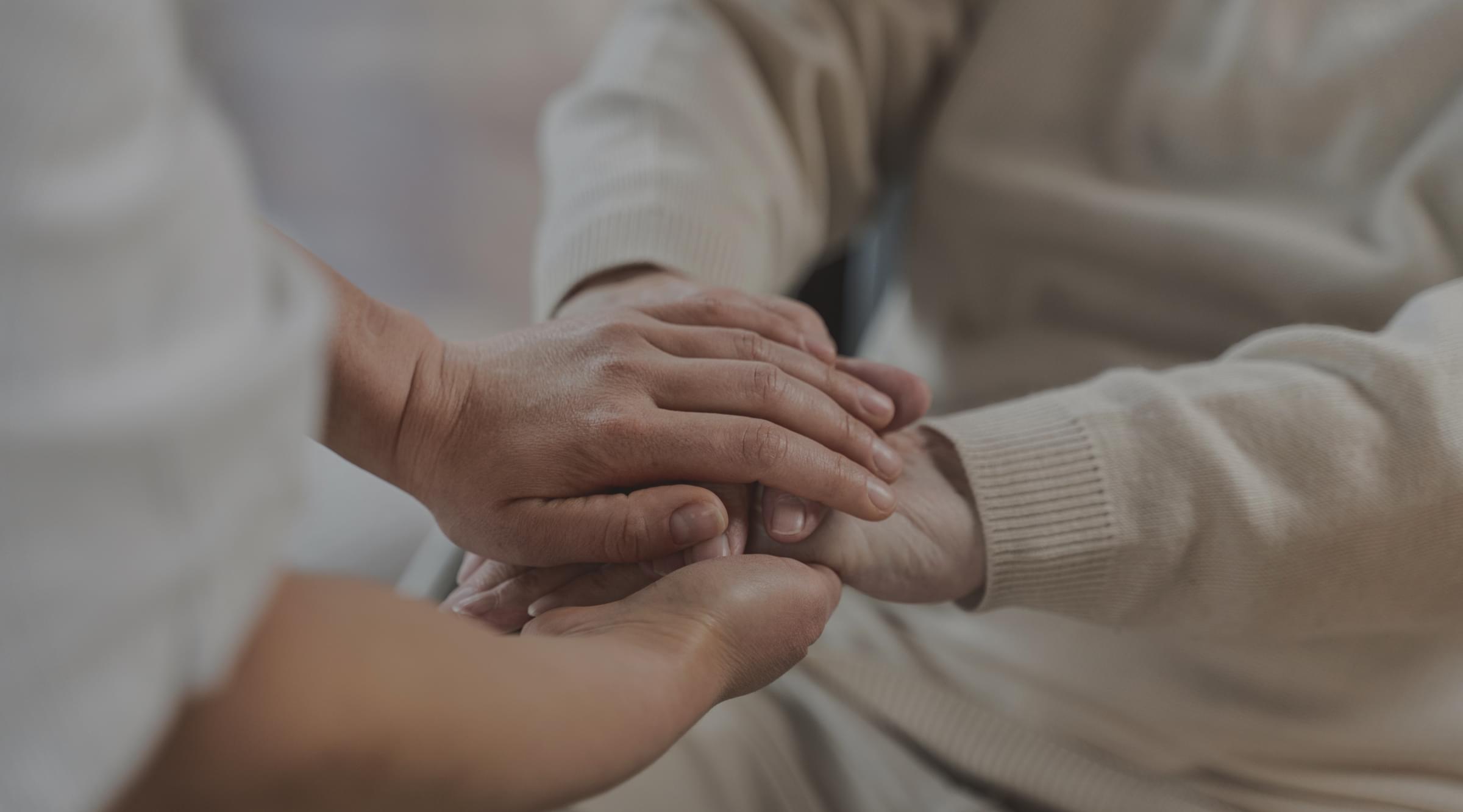 Médico de família ayundando a un paciente y cogiéndole de las manos